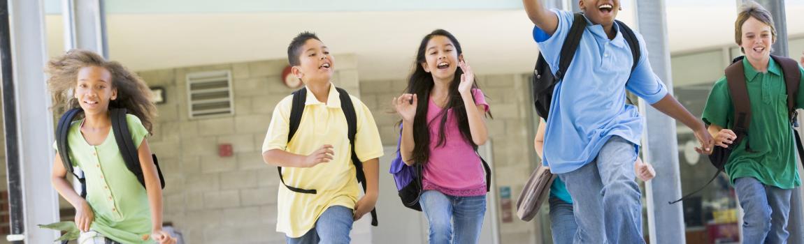 Kinder laufen und springen fröhlich durch Flur in der Schule