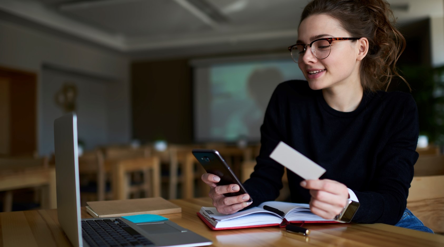 junge Frau recherchiert mit Computer und Notizbuch