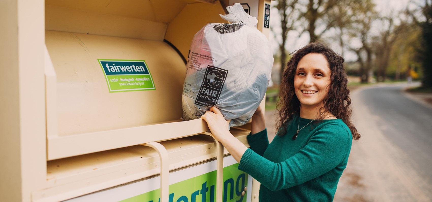 Frau vor Altkleidercontainer von FairWertung