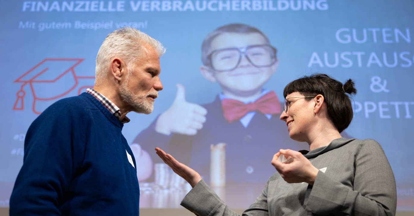 zwei Menschen diskutieren vor Leinwand