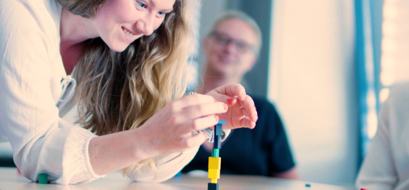 Antonia Bruns vom Projektteam stapelt kleine Bausteine und erprobt Spieleentwicklung, Copyright: Verbraucherzentrale Schleswig-Holstein